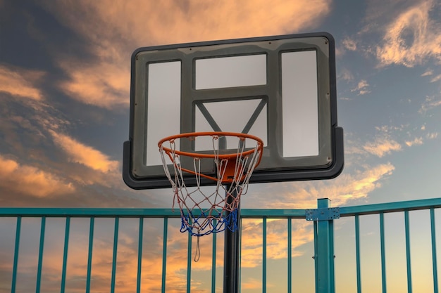 Panier de basket sur le terrain de jeu pendant le coucher du soleil