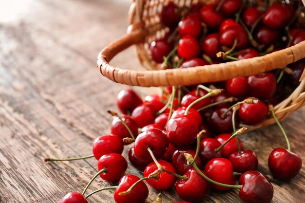 Panier avec des cerises mûres fraîches sur une table en bois