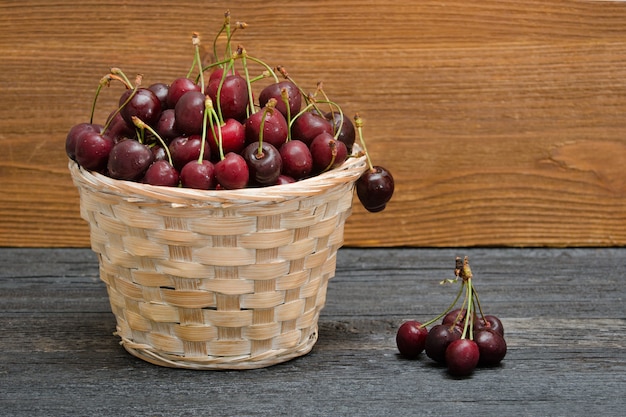 Panier de cerises sur une table en bois. Espace de copie