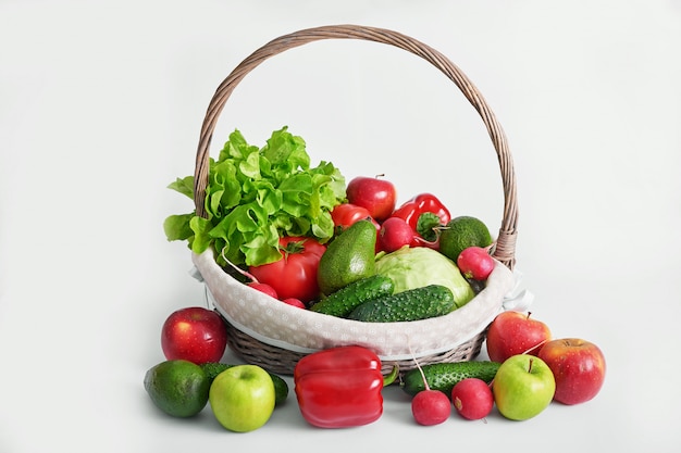 Panier avec différents légumes isolés.