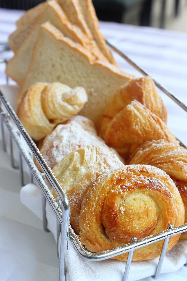 Photo panier de divers croissant de pain, denich et brioches pour le petit déjeuner sur fond blanc