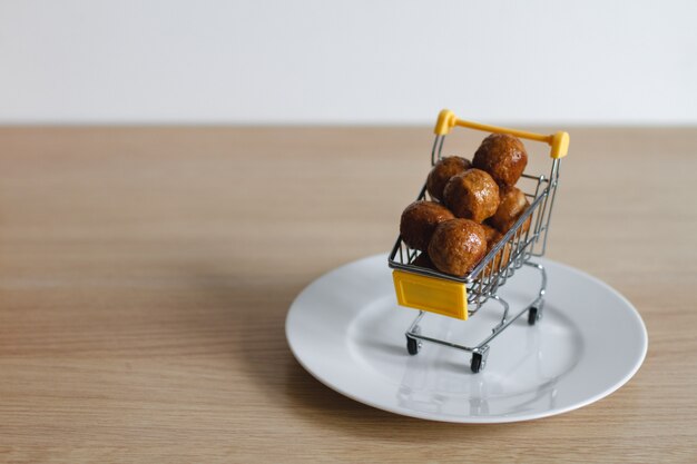 Un panier du supermarché est rempli de boulettes de viande. Le concept d'achat de nourriture