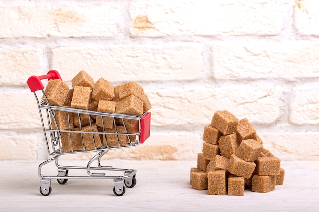 Panier d'épicerie avec des cubes de sucre de canne et un tas à proximité