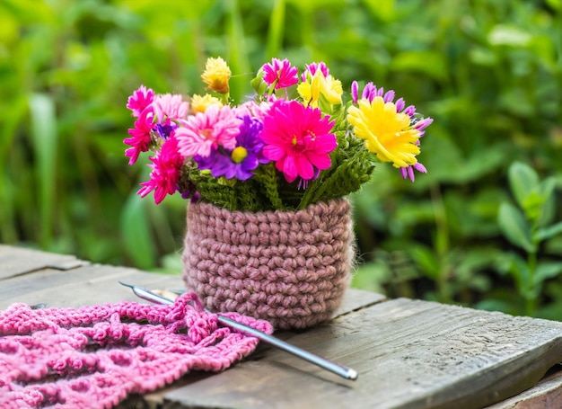 Panier de fleurs amigurumi en laine dans le jardin