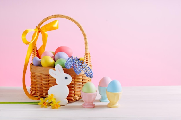 Panier avec des fleurs et des oeufs décorés pour les vacances de Pâques Oeufs colorés dans des stands d'oeufs