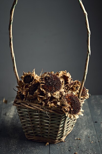 Panier de fleurs séchées sur une table en bois sombre