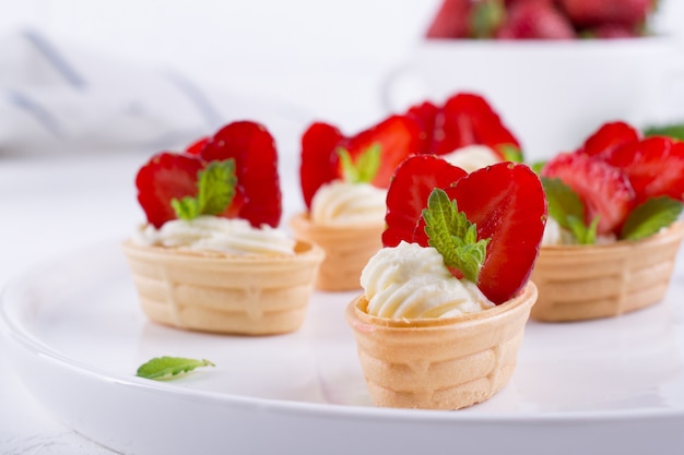 Panier de gaufres sucrées avec du fromage à la crème et des fraises pour le petit déjeuner d'été sur fond blanc