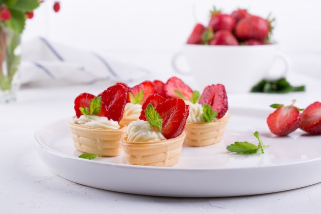 Panier de gaufres sucrées avec du fromage à la crème et des fraises pour le petit déjeuner d'été sur fond blanc