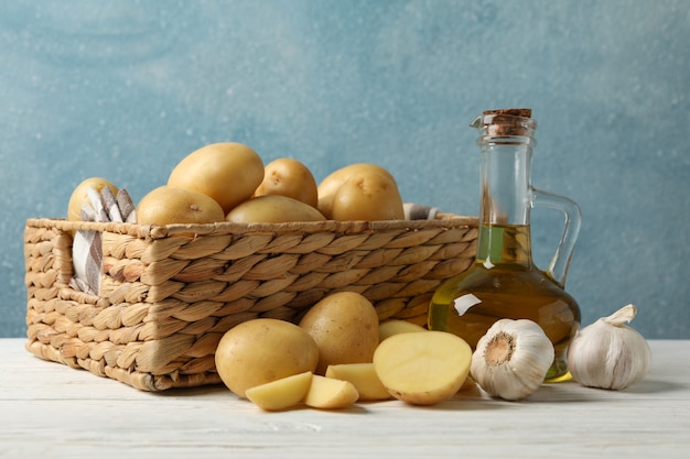 Panier de jeunes pommes de terre sur une surface en bois. Huile en bouteille