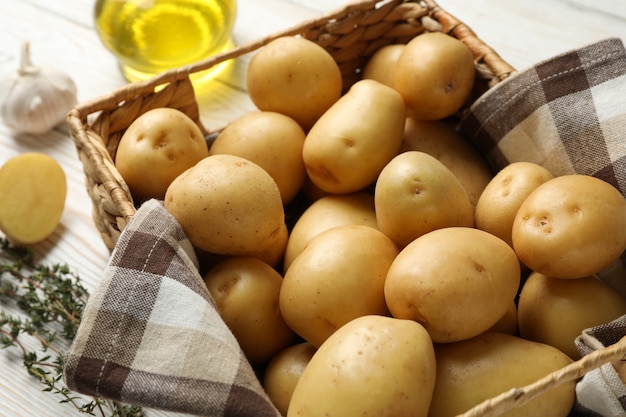 Panier avec jeunes pommes de terre sur une surface en bois