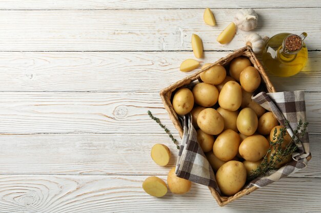 Panier avec jeunes pommes de terre sur une surface en bois