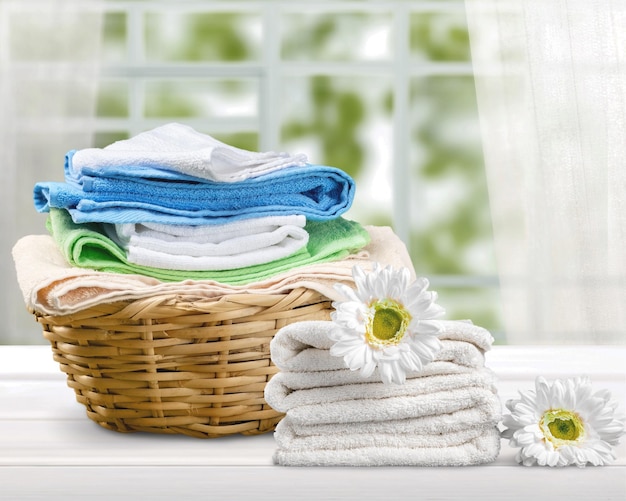 Panier à linge avec des serviettes colorées sur fond