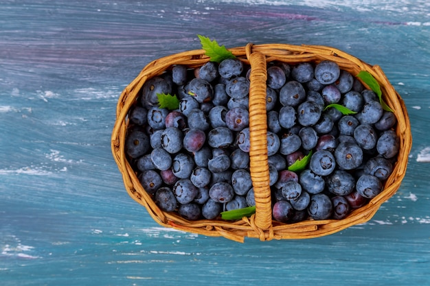 Panier avec myrtilles fraîches sur fond en bois