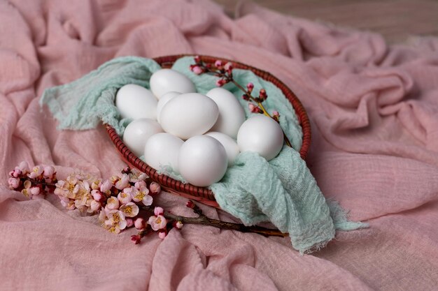 Un panier d'oeufs avec des fleurs sur la table