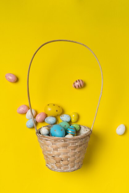 Panier avec des œufs de Pâques éparpillés.