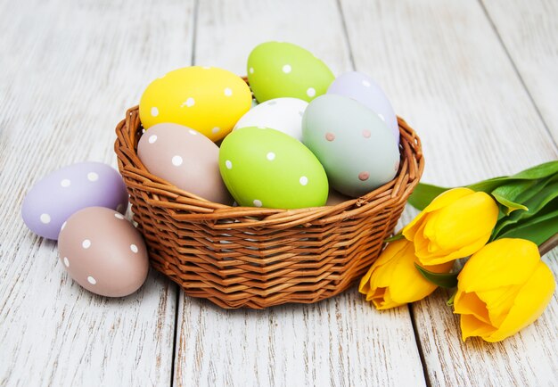 Photo panier avec oeufs de pâques et tulipes