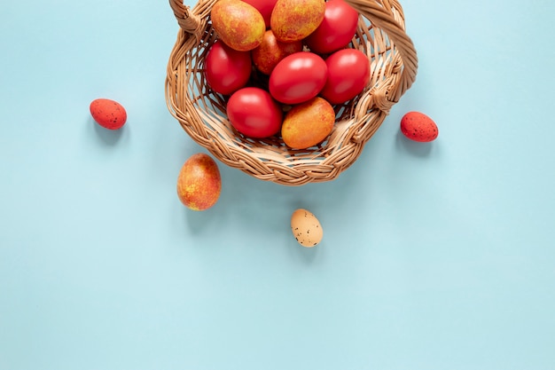 Photo panier avec des œufs peints en jaune et rouge