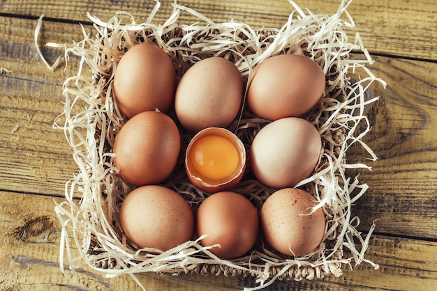 Panier d'oeufs de poule crus sur la table en bois