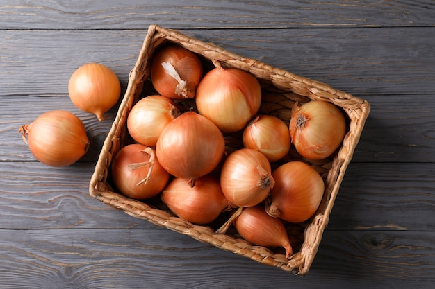 Panier avec oignon frais sur fond de bois