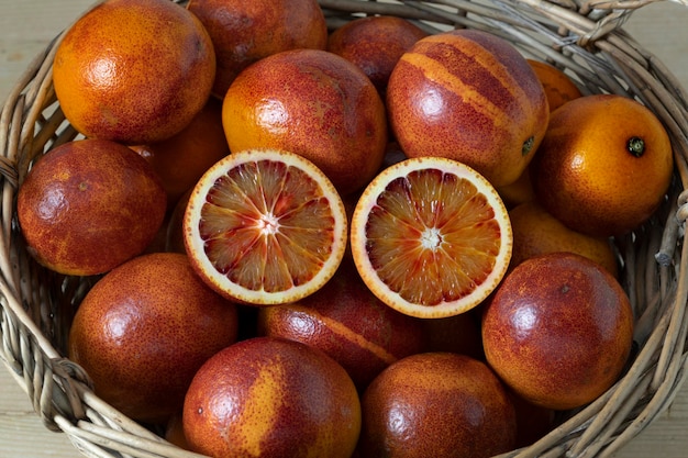 Panier avec des oranges sanguines entières et coupées en deux se bouchent