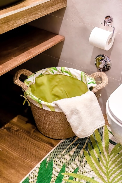 panier en osier en bois avec des serviettes sur étagère en bois pour la salle de bain