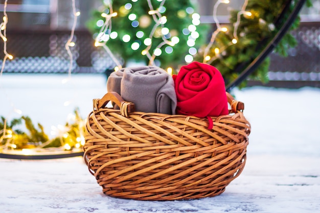 Panier en osier avec des couvertures chaudes sur la neige à l&#39;extérieur