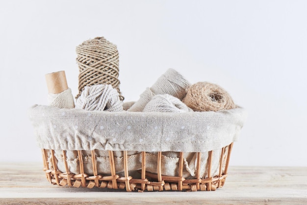 Panier en osier avec fil et fil isolé sur fond blanc