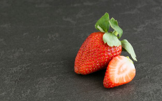 Panier en osier avec des fraises sur fond gris