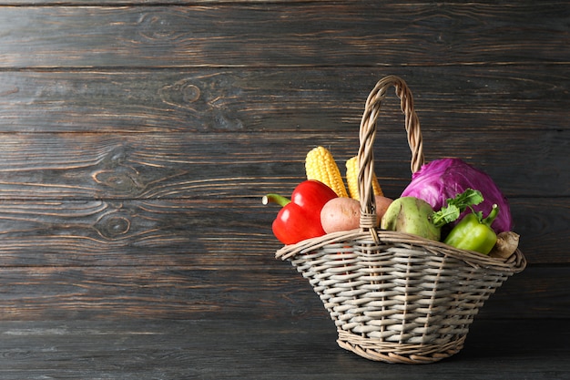 Panier en osier avec légumes sur bois