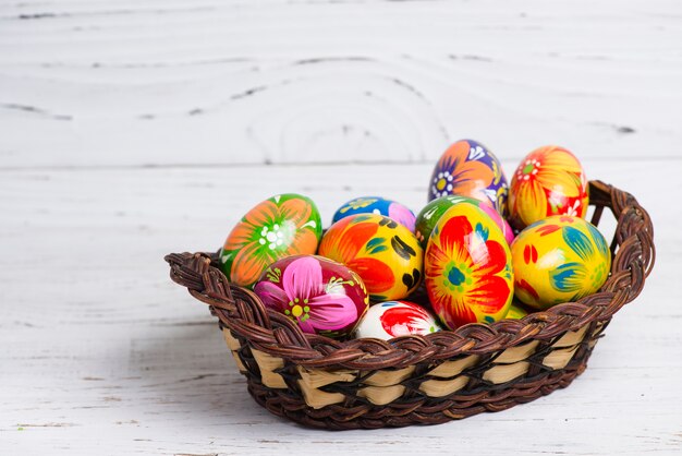 Photo panier en osier avec des oeufs colorés pour le jour de pâques