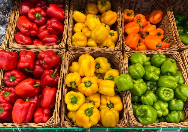Photo panier en osier de poivrons sur le comptoir du magasin. marché fermier légumes frais produits naturels