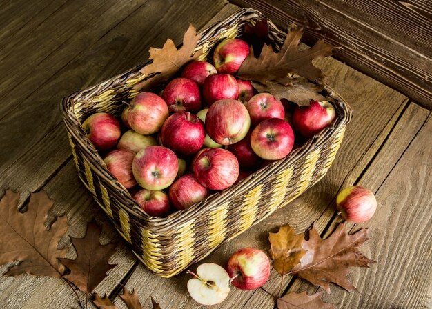 Panier en osier avec des pommes sur une table en bois