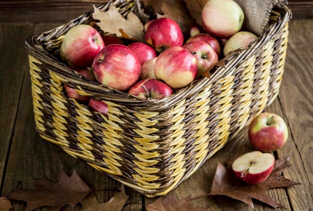 Panier en osier avec des pommes sur une table en bois