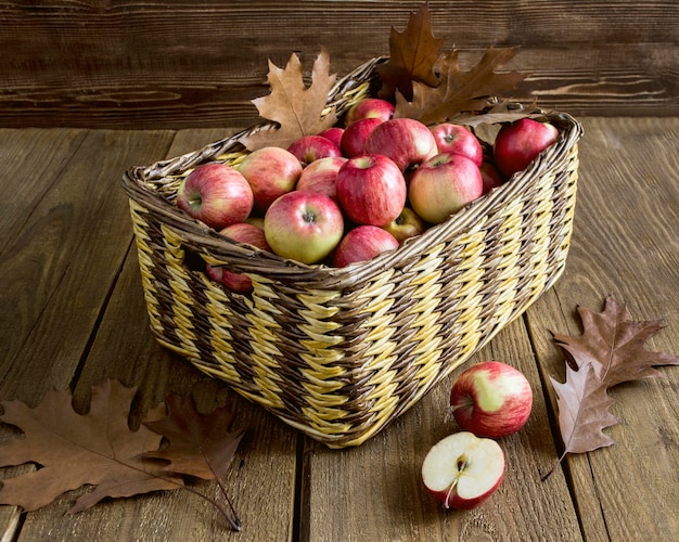 Panier en osier avec des pommes sur une table en bois