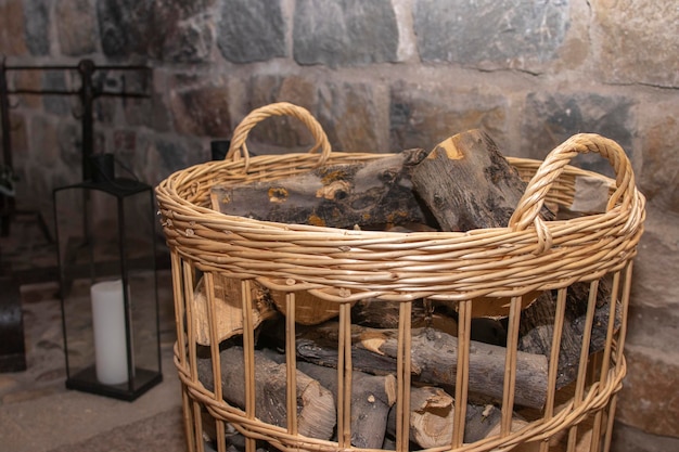 Photo un panier en osier rempli de bois de chauffage à côté d'une cheminée