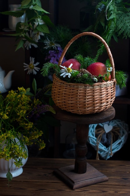 Un panier en osier rempli de tomates mûres Épicerie d'été nature morte sur une récolte de fond en bois