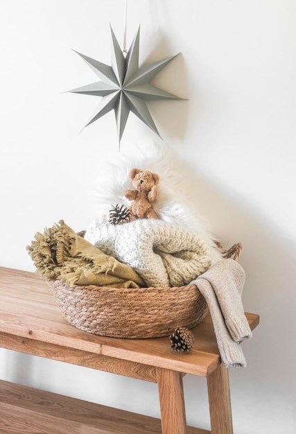 Un panier de paille avec des couvertures confortables sur un banc en bois une étoile de Noël sur le mur à l'intérieur de la chambre des enfants