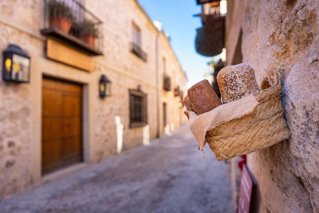 Panier de pain artisanal suspendu à la façade d'une boulangerie dans le village médiéval de Pedraza Segovia