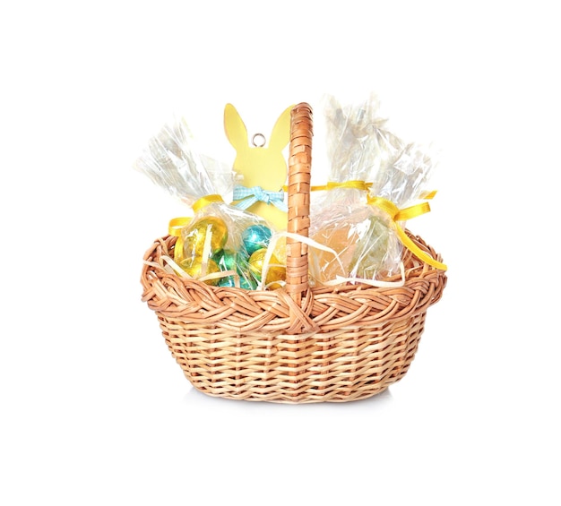 Photo panier de pâques avec des bonbons et des cadeaux sur fond blanc