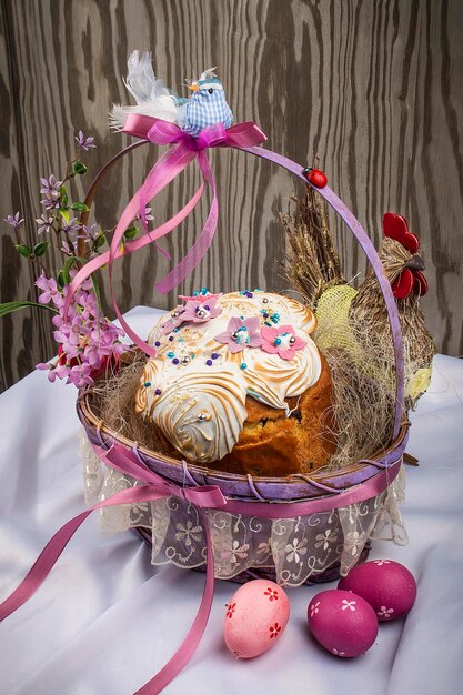 Panier de Pâques décoratif avec gâteau et oeufs colorés sur une table en bois