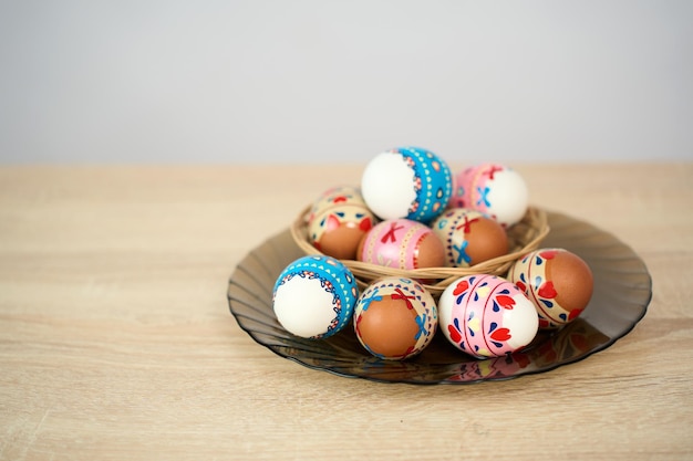 Un panier de Pâques avec des œufs de Pâques colorés sur une table en bois.