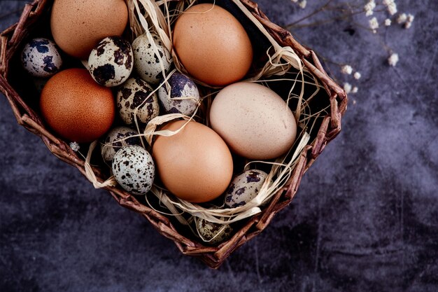 Panier de Pâques avec des oeufs de Pâques sur un fond de béton plâtré