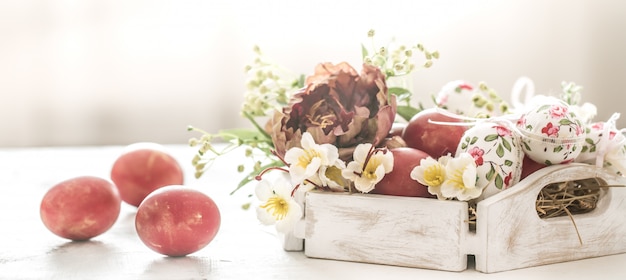 Panier de Pâques et oeufs rouges avec des fleurs