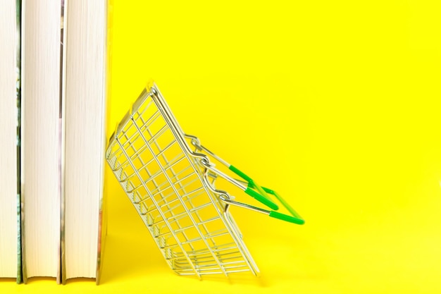 Photo panier et une pile de livres sur fond jaune.