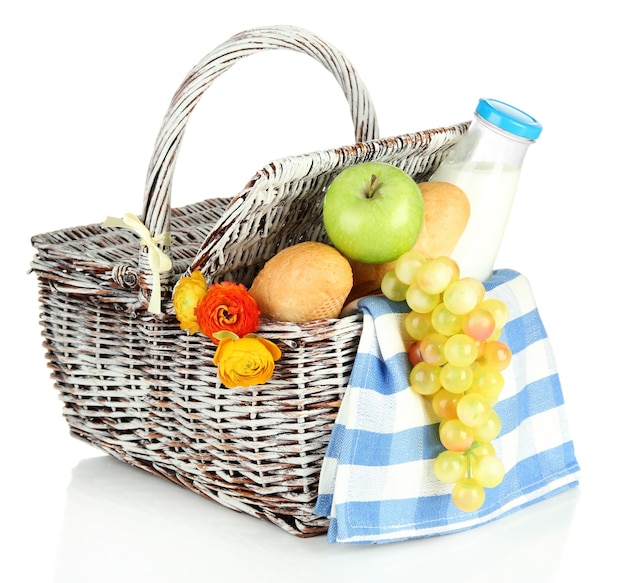 Panier pique-nique avec fruits et bouteille de lait isolé sur blanc