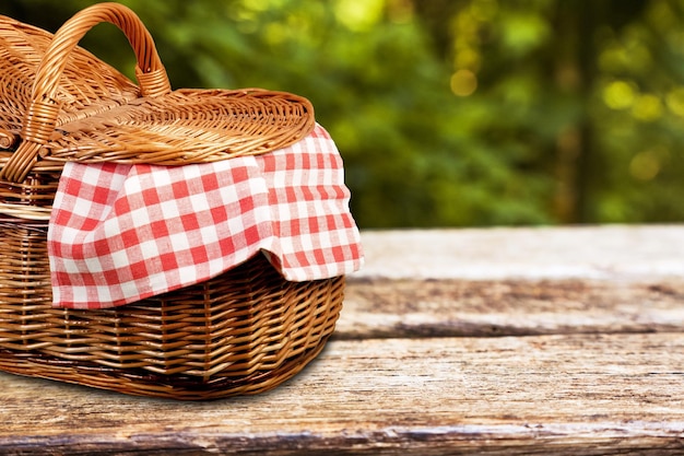 Panier pique-nique avec une nappe sur une table en bois