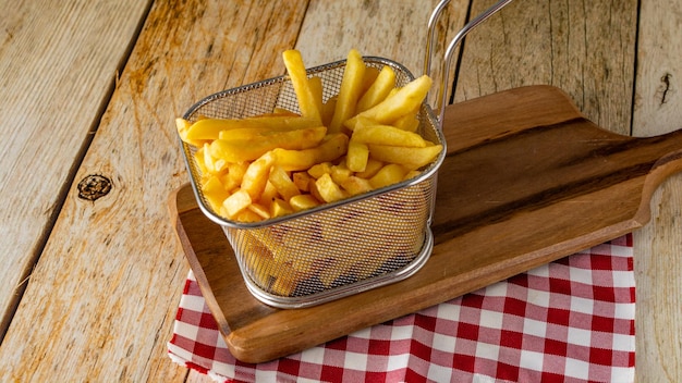 Panier plein de frites sur table en bois rustique