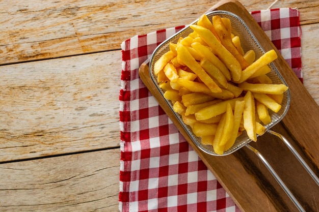 Panier plein de frites sur table en bois rustique