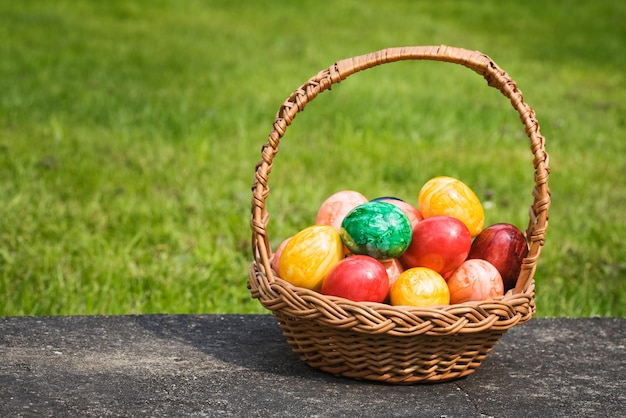 Panier plein d'oeufs de Pâques sur une dalle de pierre