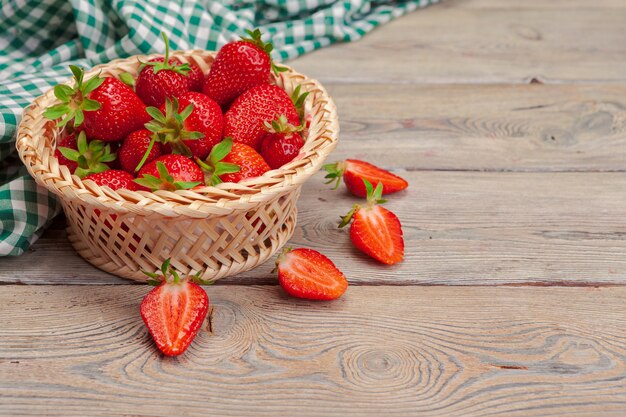 Panier de récolte de fraises sur table en bois se bouchent